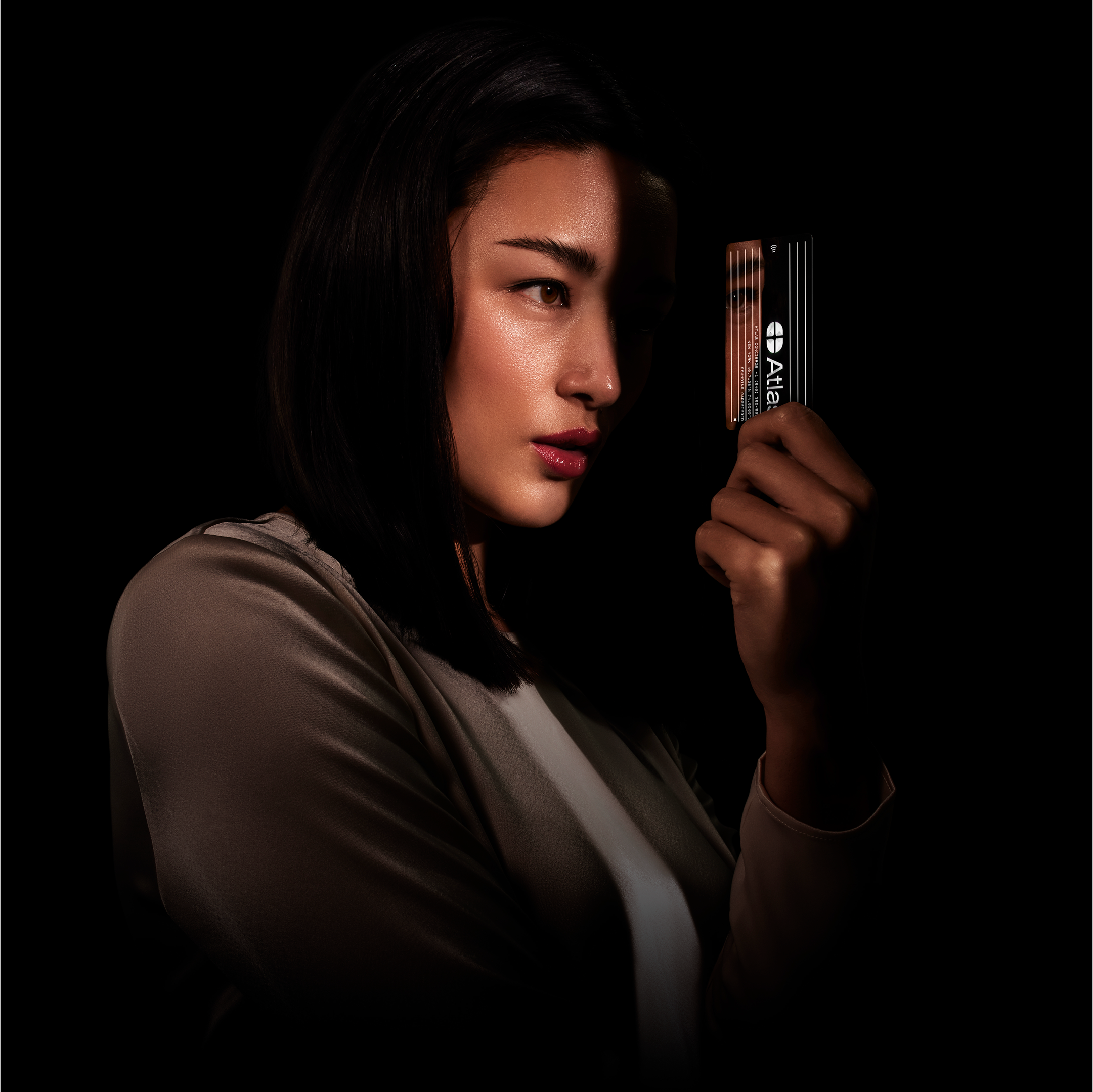 A woman holds the beautiful Atlas Card — the super-mirror finish surface reflects the person's face inside the card.