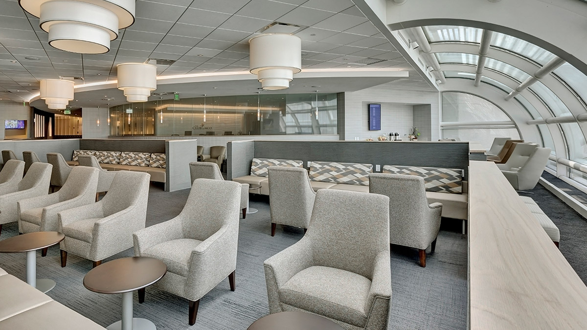 A number of empty chairs in a luxurious and modern airport waiting area.