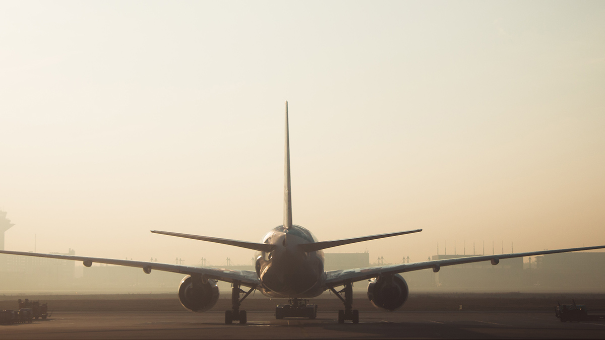 A photo of a plane either taking off or landing from a runway on a late foggy day.